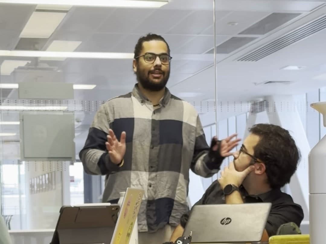 A MindHug facilitator leading a workshop while a participant listens at the table